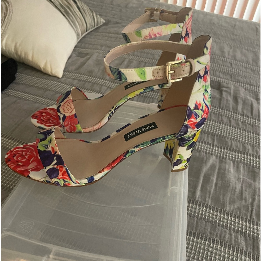 A pair of multicolored dress or casual sandals with ankle strap and small heell.